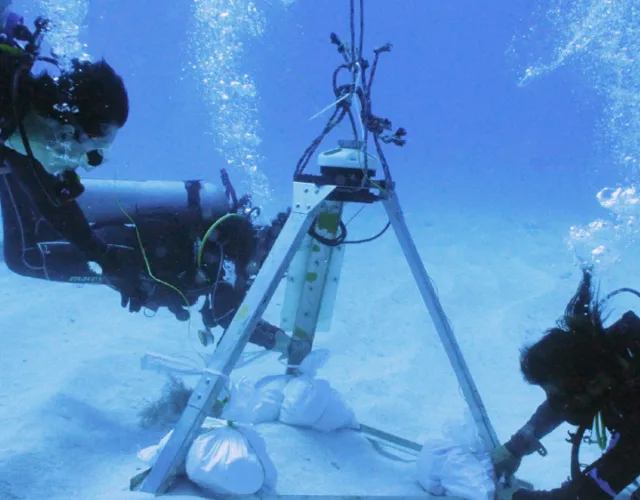 Divers deploying Nortek ADCP ocean current measurement equipment underwater